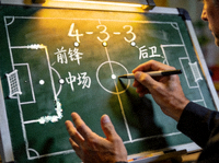 足球战术板与教练手势近景，分析比赛阵型